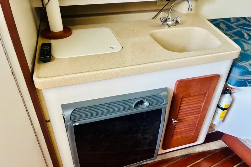 Slide: The Image of Compact kitchenette in a 2002 Pursuit 3000 Express boat with sink, stove, and storage. - 40