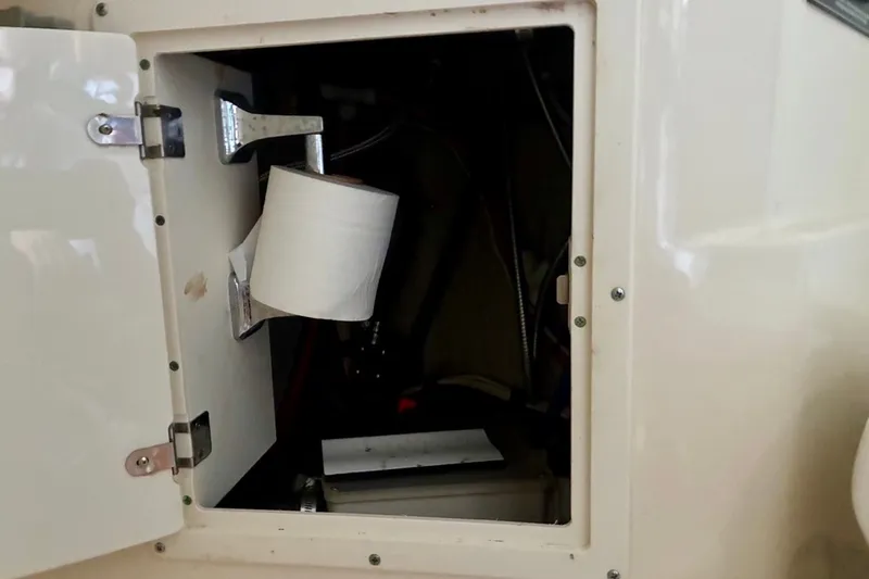 Slide: The Image of Open cabinet on 2002 Pursuit 3000 Express boat with toilet paper holder inside. - 44