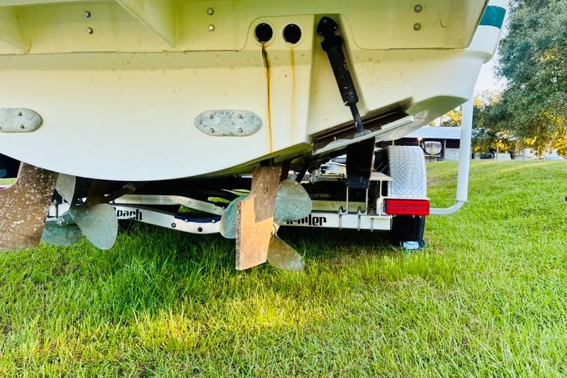 Slide: The Image of Rear view of a 2002 Pursuit 3000 Express boat on a trailer, showing propellers. - 82