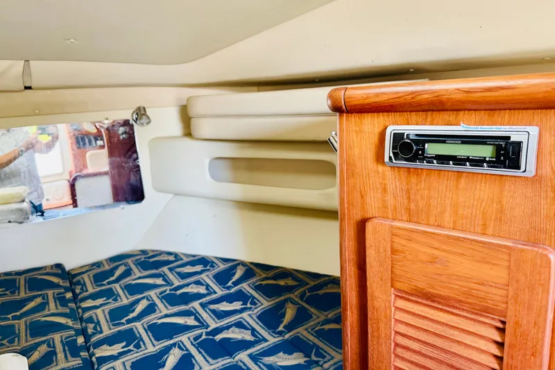 Slide: The Image of Interior of 2002 Pursuit 3000 Express boat with wood paneling and patterned cushions. - 13