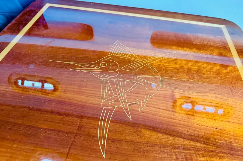 Slide: The Image of Wooden table with marlin engraving on a 2002 Pursuit 3000 Express boat. - 10
