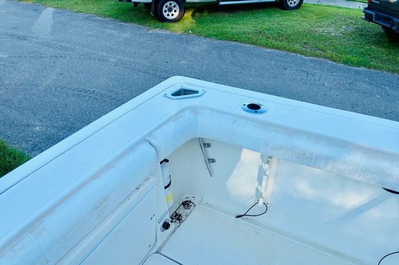 Slide: The Image of 2002 Pursuit 3000 Express boat interior with storage compartments and rod holders. - 81
