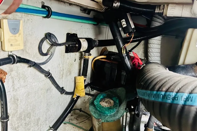 Slide: The Image of Engine compartment of a 2002 Pursuit 3000 Express boat, showcasing wiring and hoses. - 36
