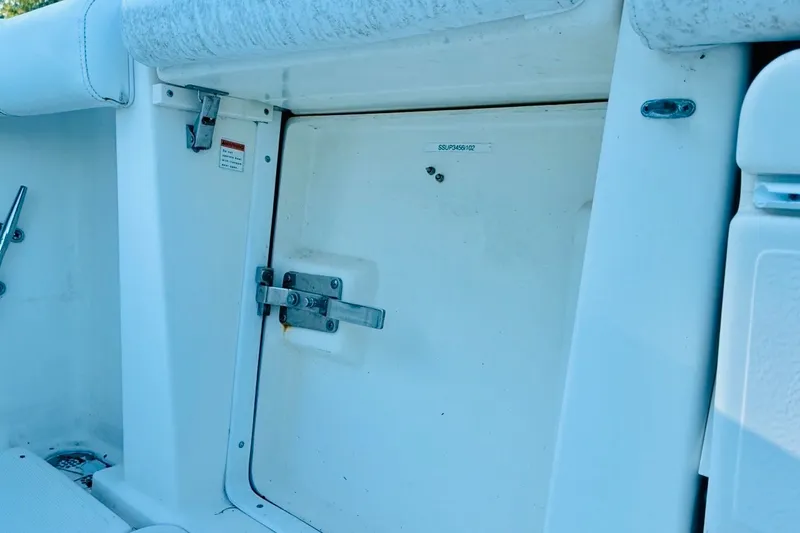 Slide: The Image of 2002 Pursuit 3000 Express boat interior, featuring a secured hatch door with metal latch. - 79