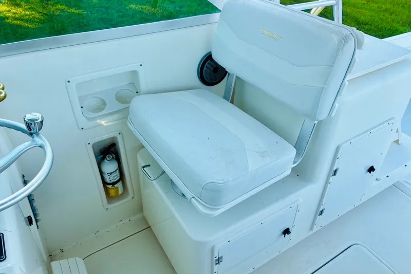 Slide: The Image of 2002 Pursuit 3000 Express boat interior with white captain's chair and steering wheel. - 59