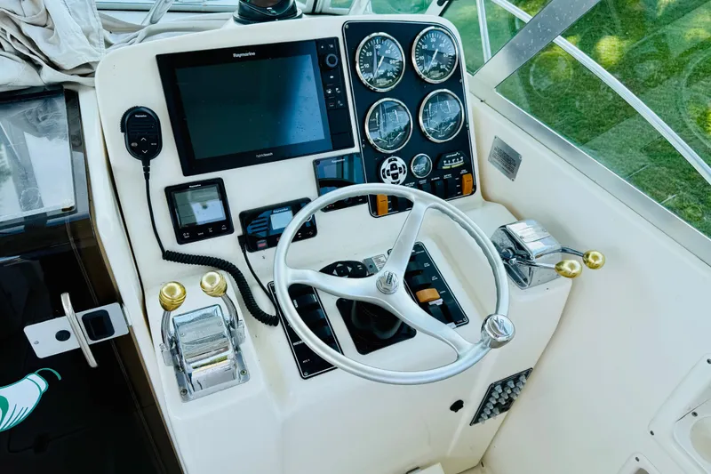 Slide: The Image of Control panel of a 2002 Pursuit 3000 Express boat with steering wheel and gauges. - 7