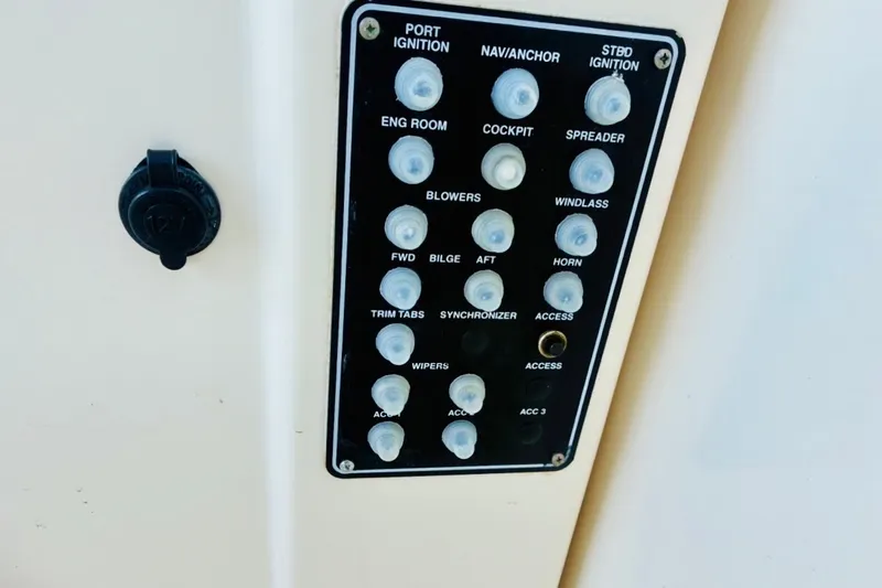 Slide: The Image of Control panel of a 2002 Pursuit 3000 Express boat with labeled switches and buttons. - 58