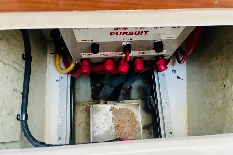 Slide: The Image of Electrical panel of a 2002 Pursuit 3000 Express boat with labeled switches and cables. - 52