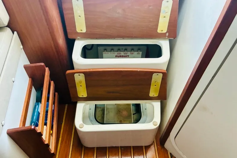 Slide: The Image of Interior view of a 2002 Pursuit 3000 Express boat showing wooden storage compartments. - 53