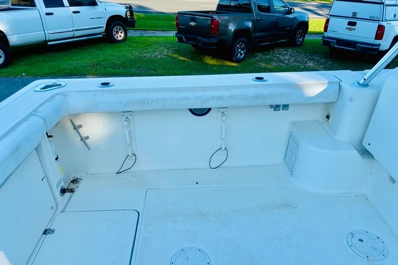 Slide: The Image of 2002 Pursuit 3000 Express boat deck with rod holders and storage compartments. - 22
