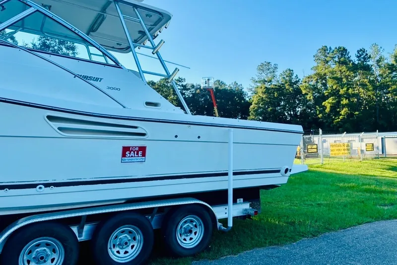 Slide: The Image of 2002 Pursuit 3000 Express boat for sale on trailer, parked on grass. - 87