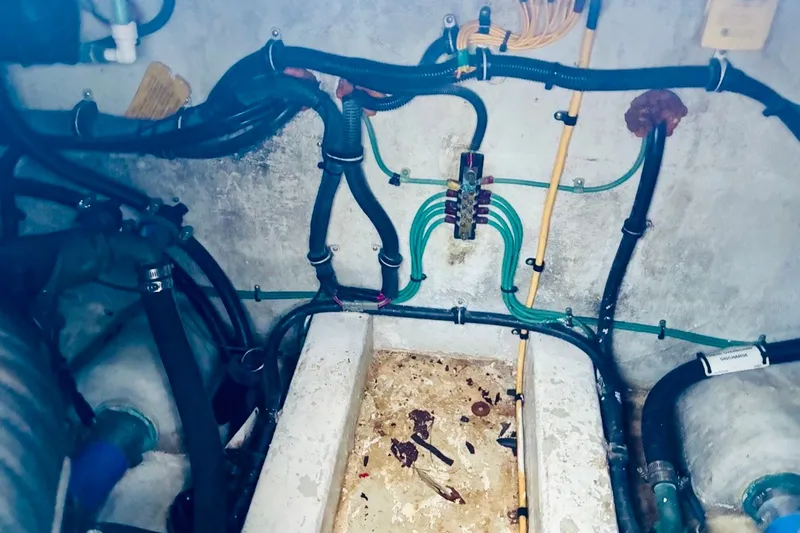 Slide: The Image of Engine compartment of a 2002 Pursuit 3000 Express boat, showing wiring and hoses. - 38