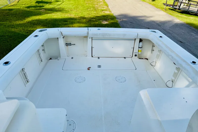 Slide: The Image of 2002 Pursuit 3000 Express boat deck with white seating and storage compartments. - 9