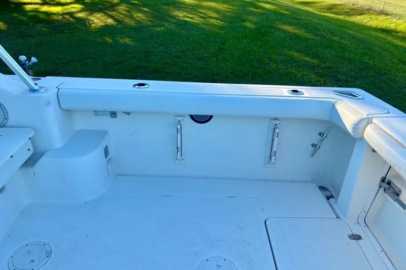 Slide: The Image of 2002 Pursuit 3000 Express boat interior with white seating and fishing rod holders. - 23