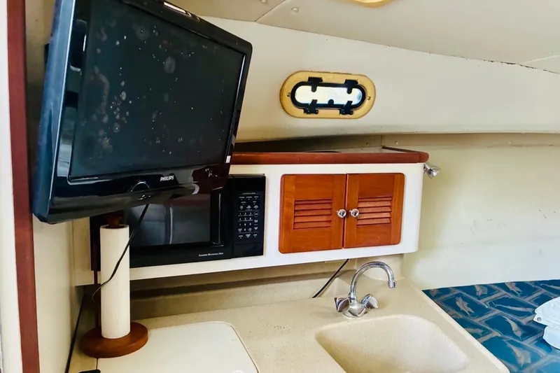 Slide: The Image of 2002 Pursuit 3000 Express cabin with TV, microwave, and sink. - 39