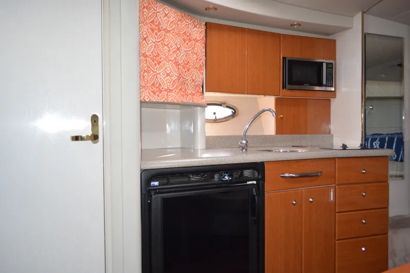 Slide: The Image of Interior of a 2002 Formula 37 Performance Cruiser kitchen with wood cabinets and appliances. - 38