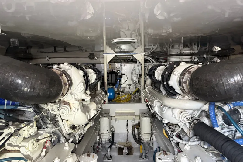 Slide: The Image of The engine room of a 2002 Viking 52 Convertible features two large engines and piping. - 44
