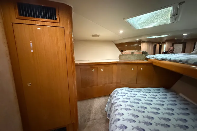 Slide: The Image of 2002 Viking 52 Convertible yacht interior with wooden cabinetry and cozy sleeping area. - 35