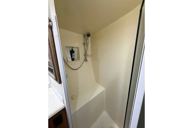 Slide: The Image of Shower area inside a 2002 Viking 52 Convertible yacht, featuring a handheld showerhead. - 32