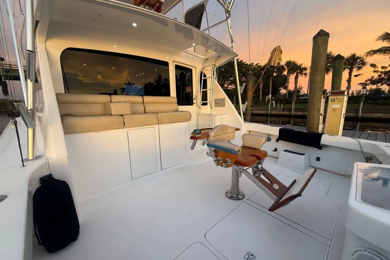 Slide: The Image of 2002 Viking 52 Convertible yacht deck with seating and fishing chair at sunset. - 3