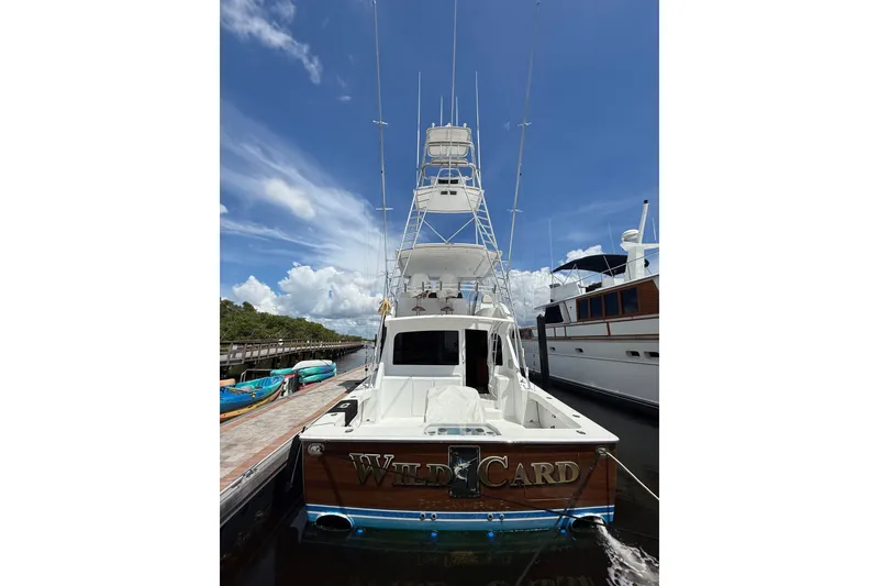 Slide: The Image of 2002 Viking 52 Convertible yacht docked under a clear blue sky. - 52