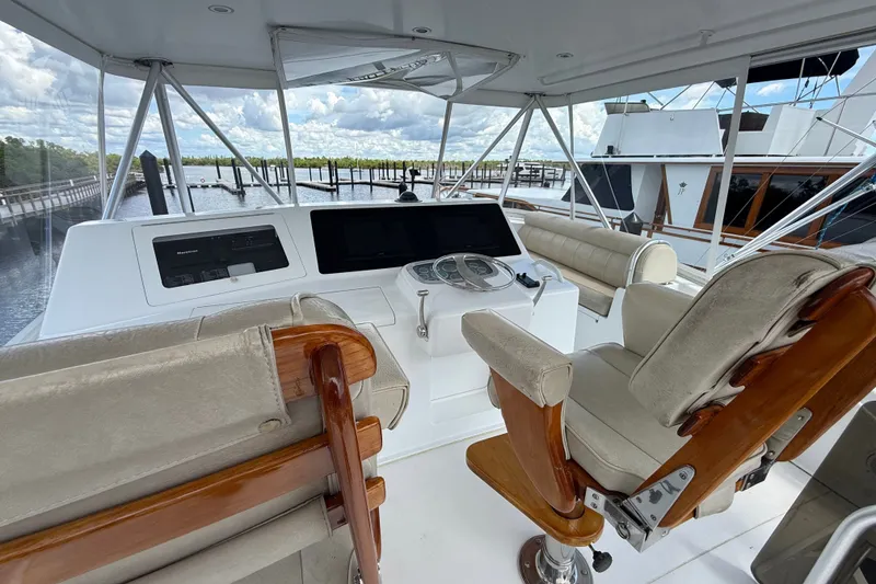 Slide: The Image of Helm of 2002 Viking 52 Convertible yacht with plush seating and navigation controls. - 11