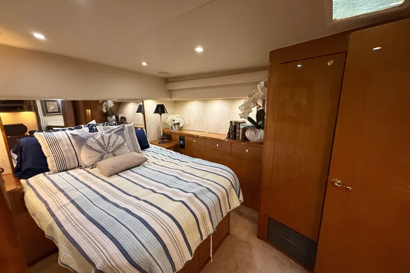 Slide: The Image of Luxurious bedroom interior of 2002 Viking 52 Convertible yacht with striped bedding. - 28
