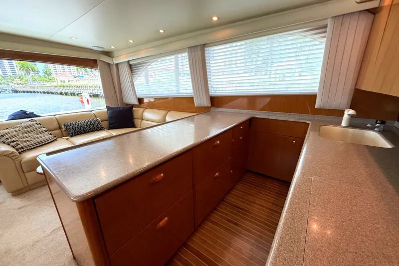 Slide: The Image of Interior of a 2002 Viking 52 Convertible with a sleek kitchen and cozy seating area. - 26