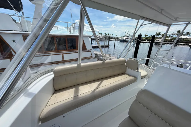 Slide: The Image of 2002 Viking 52 Convertible yacht interior with beige seating and marina view. - 17