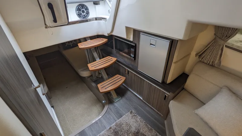 Slide: The Image of Interior of a 2021 Sea Ray Sundancer 320 Outboard with seating area and small kitchenette. - 18