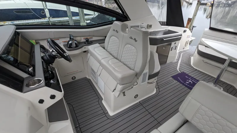 Slide: The Image of The image shows the cockpit of a 2021 Sea Ray Sundancer 320 Outboard with sleek seating and modern features. - 10
