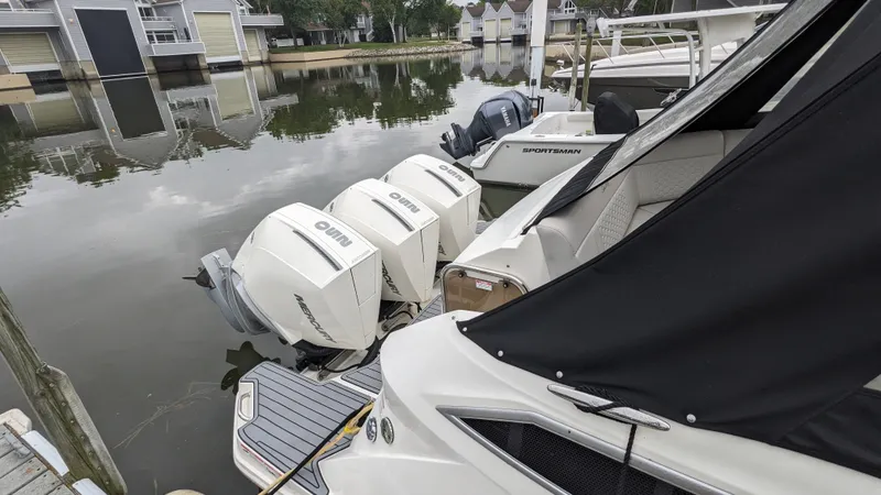 Slide: The Image of A 2021 Sea Ray Sundancer 320 Outboard docked. Three outboard engines are visible. - 28