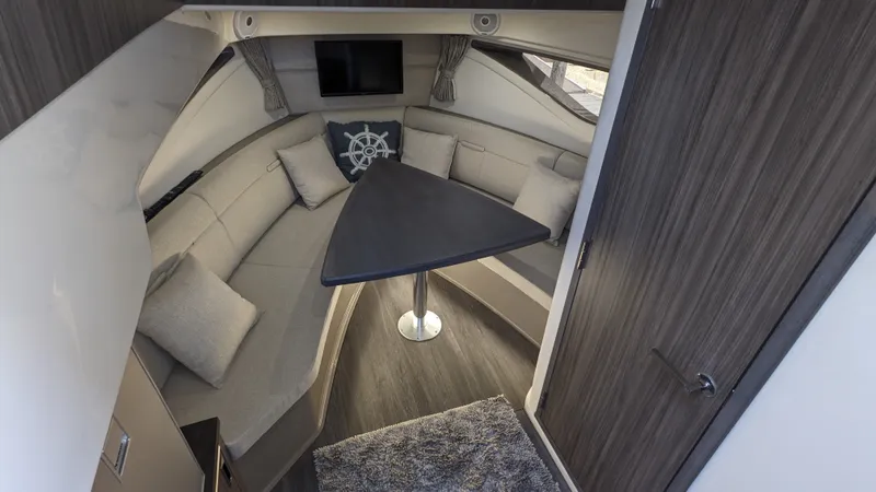 Slide: The Image of Interior of a 2021 Sea Ray Sundancer 320 Outboard with a cozy seating area and table. - 17