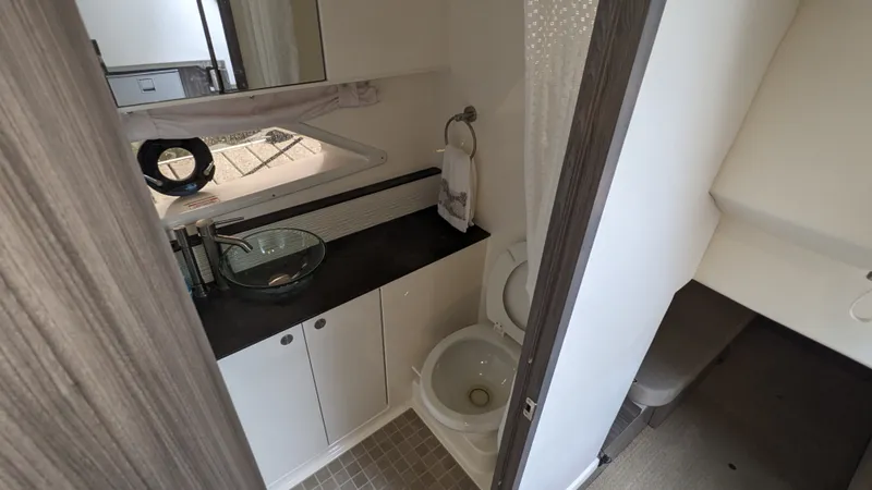 Slide: The Image of The image shows a modern boat bathroom with a sink, toilet, and mirror. - 23