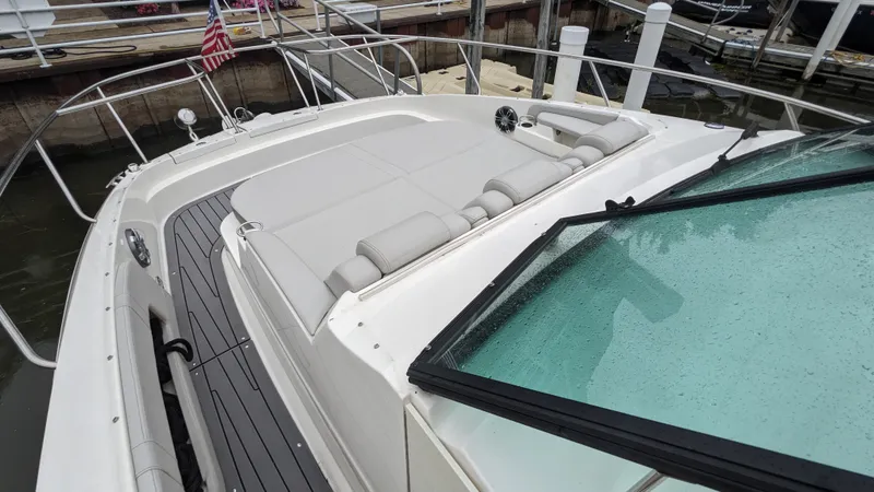 Slide: The Image of The image shows the foredeck of a 2021 Sea Ray Sundancer 320 Outboard with a lounging area. - 12