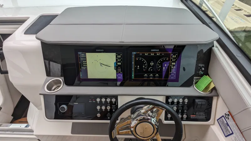 Slide: The Image of The image shows the helm of a Sea Ray Sundancer 320 Outboard with modern instruments and screens. - 13