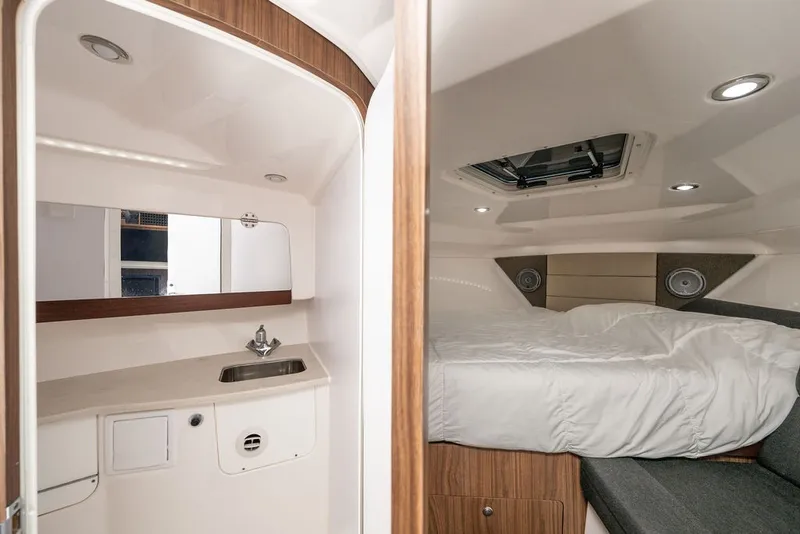 Slide: The Image of The 2019 Everglades 350LX cabin features a cozy bed and a small sink. - 23