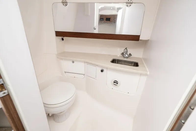 Slide: The Image of The image shows a clean, modern boat bathroom with a toilet, sink, and mirror. - 25