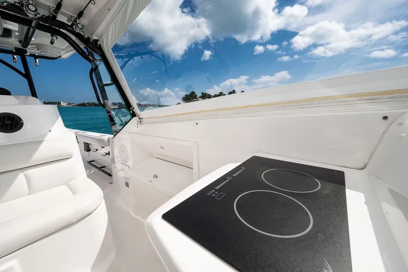 Slide: The Image of The image shows the cockpit of a 2019 Everglades 350LX with a cooktop and white seating. - 20