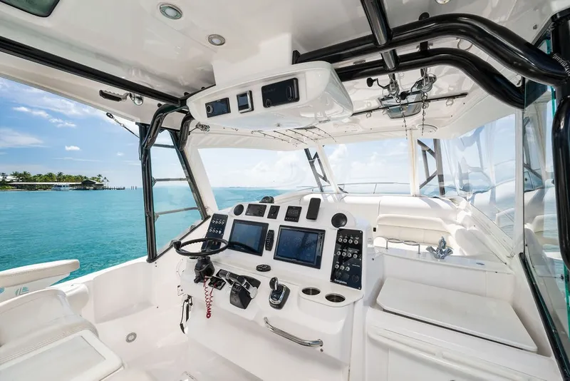 Slide: The Image of The image shows the cockpit of a 2019 Everglades 350LX with modern instruments and a clear view of the sea. - 13