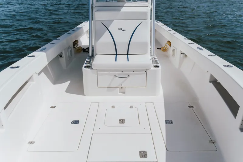 Slide: The Image of 2014 SeaVee 320B boat interior with seating and storage, on calm water. - 16