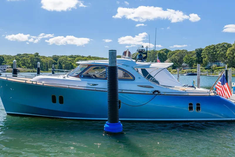 Slide: The Image of 2014 Zeelander Z44 yacht docked in a scenic marina under a clear blue sky. - 0