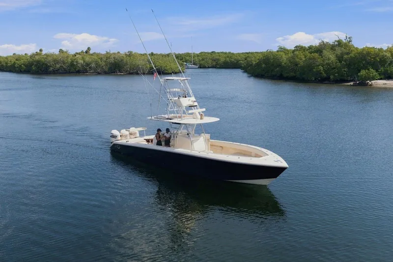 Slide: The Image of A sleek boat with two people on board navigates calm waters, surrounded by lush greenery. - 1