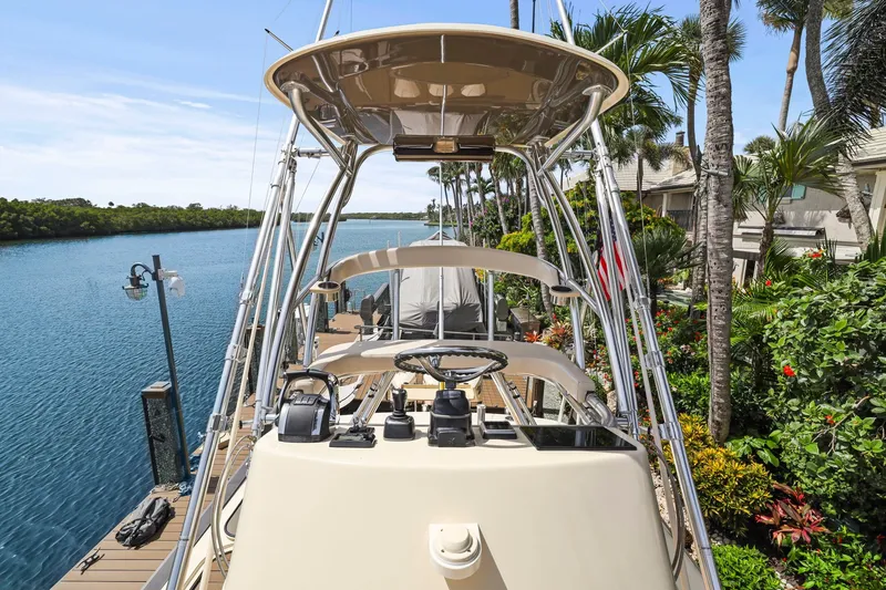 Slide: The Image of 2013 Bahama 41 boat docked by tropical waterfront with lush greenery. - 40