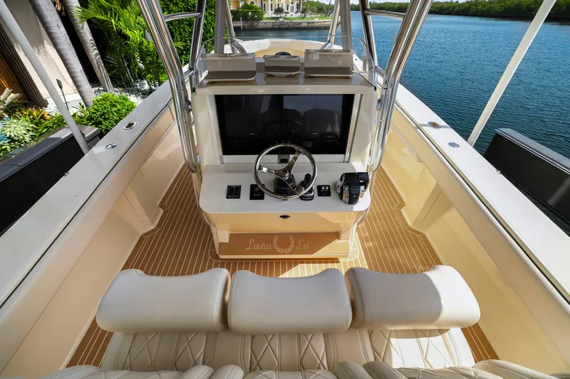 Slide: The Image of Luxurious 2013 Bahama 41 boat cockpit with modern steering and controls, docked by lush greenery. - 22