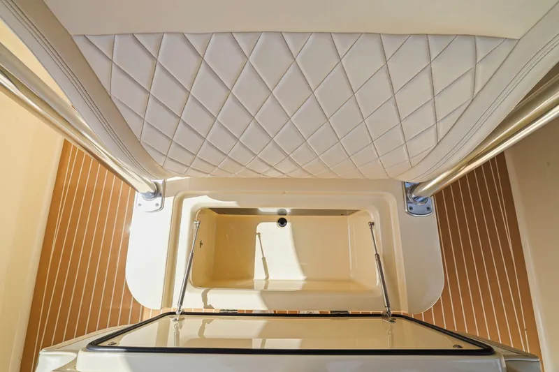 Slide: The Image of Interior view of a 2013 Bahama 41 boat, featuring quilted upholstery and storage compartment. - 17