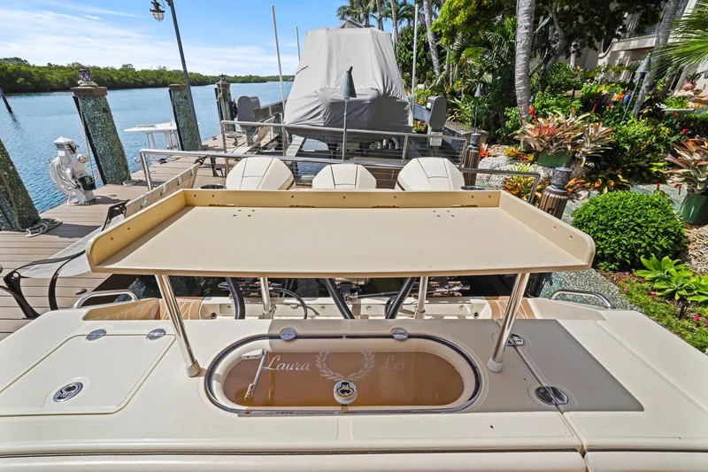 Slide: The Image of 2013 Bahama 41 boat docked, featuring a fishing station and lush tropical surroundings. - 32
