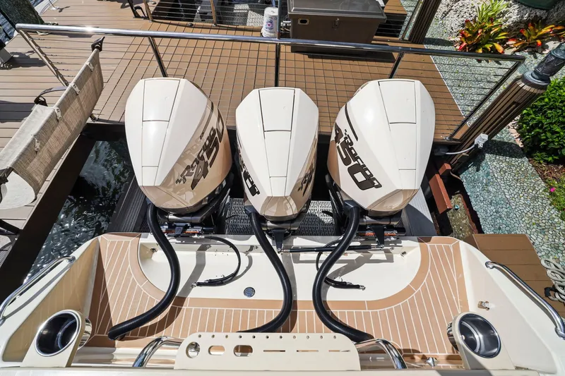 Slide: The Image of Triple outboard engines on a 2013 Bahama 41 boat, docked with wooden decking. - 34