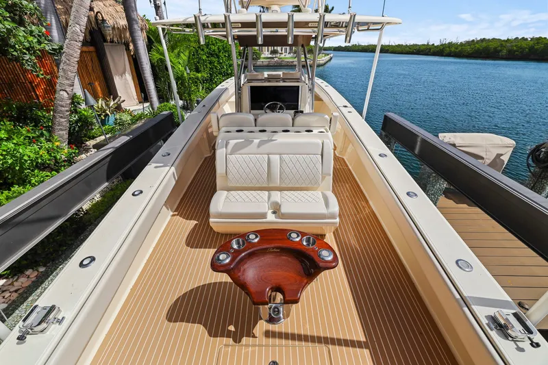 Slide: The Image of Luxurious 2013 Bahama 41 boat interior with seating, docked by lush greenery. - 25