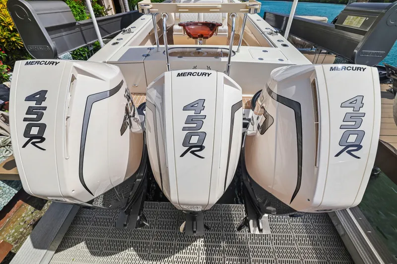Slide: The Image of Triple Mercury 450R engines on a 2013 Bahama 41 boat, docked by the water. - 35